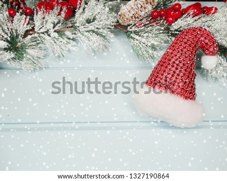 christmas decor santa cap with fir tree branch cones and snow on background 