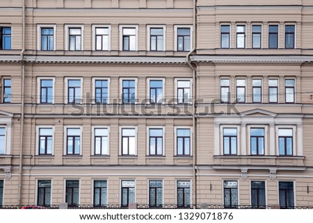 Fragment of an old building facade with ornate decoration in the center of St. Petersburg at sunny day, Russia.