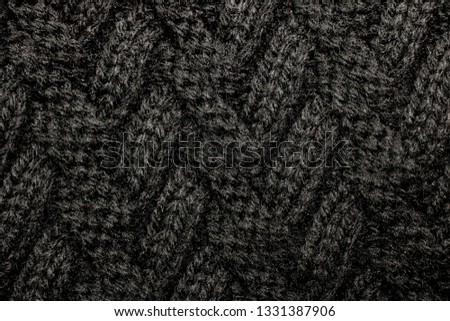 Pattern on black wool knitted fabric, texture or background for text