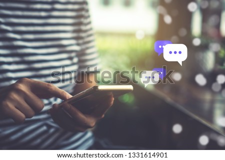 Women hand using smartphone typing, chatting conversation in chat box icons pop up. Social media maketing technology concept.Vintage soft color tone background.