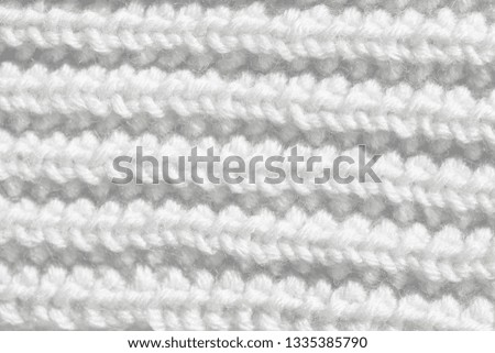 The background is white. The texture of the knitted fabric is made of woolen threads handmade.