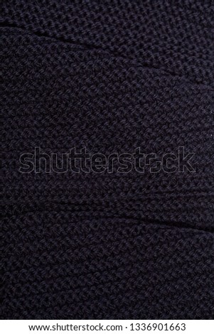 Knitted black scarf texture background.