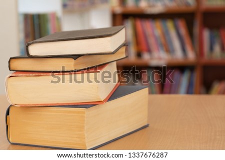 Book in library with old open textbook, stack piles of literature text archive on reading desk, and aisle of bookshelves in school study class room background for academic education learning concept 