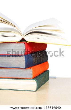 A stack of multicolored thick hardcover books isolated on white