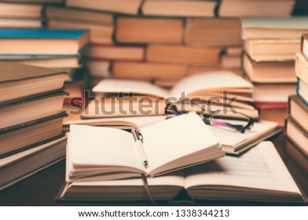 Open book and glasses on wood desk in the library room with narrow depth of field for education background and back to school concept