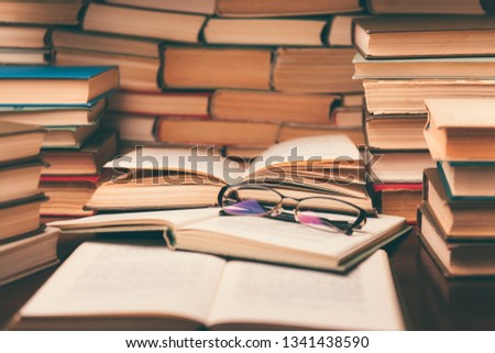 Open book and glasses on wood desk in the library room with blurred focus for education background and back to school concept