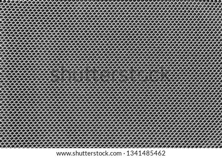 photo of textured surface of uniformly distributed grid pattern similar to chain fastening in multiple magnification. texture and close-up