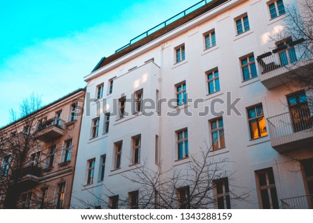 white apartment house next to an brown building at berlin