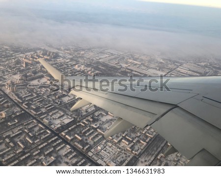 wing of the plane against the snowy city