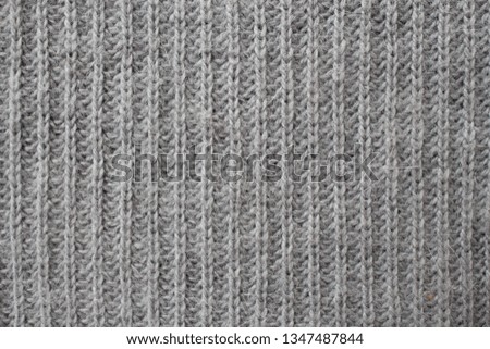Gray knitted plaid scarf for background. Gray knitted texture. Yarn texture background.