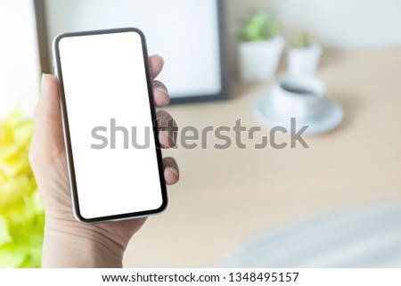 mockup image of cell phone white blank screen for text.Businessman at workplace Think business investment plan.Contact Investor using mobile,computer.make note appointment information in the notebook