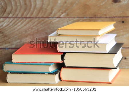 Stack of books in various colors on the wooden floor selective focus and shallow depth of field