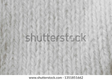 White knitted texture closeup, visible yarn and fiber. The image is suitable as a background for various tasks.
