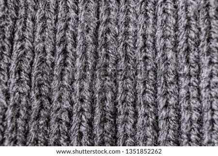 Gray knitted texture closeup, visible yarn and fiber. The image is suitable as a background for various tasks.