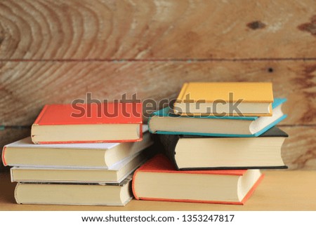 Stack of books in various colors on the wooden floor old wooden floor as background selective focus and shallow depth of field