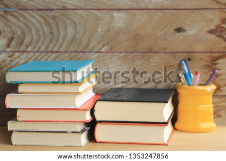 Stack of books in various colors on the wooden floor old wooden floor as background selective focus and shallow depth of field