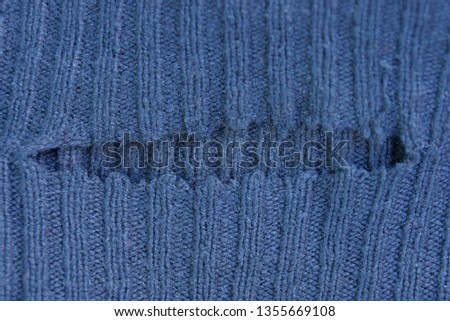 gray background of cloth from torn clothes with a hole