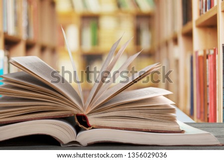 Open book on old wooden table at library background