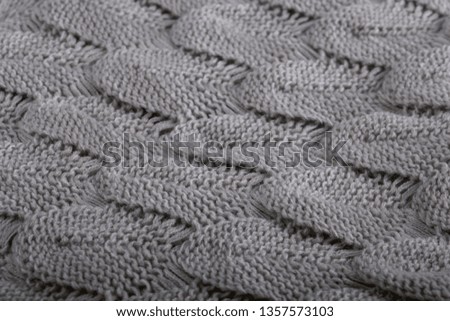 filled frame detailed close up wallpaper background macro shot of a grey soft fluffy woollen knitted mermaid tail lap blanket fabric texture forming beautiful shapes and patterns