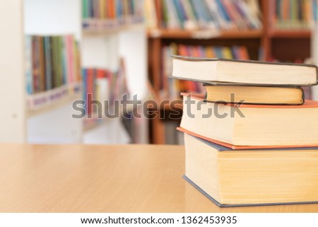 Book in library with old open textbook, stack piles of literature text archive on reading desk, and aisle of bookshelves in school study class room background for academic education learning concept 