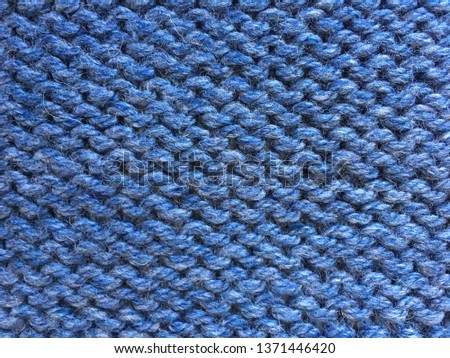 Background texture of knitted wool blue color.  knitted sweater closeup jeans color