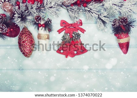 christmas bell with fir tree branch cones and snow on background with garland lights