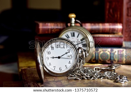 Elegant pocket watches and books on the table