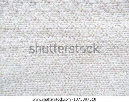 Knitted clothes from wool yarn. Background of wool yarn for yarn frame. White knitting yarn for handicrafts background.