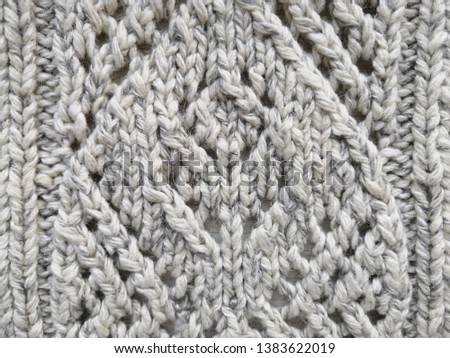 Knitted light background. Woolen thread pattern. 