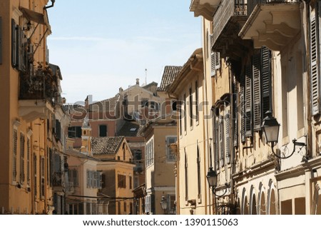 Corfu Town architecture with buildings on both sides of the street shot from the second floor up.