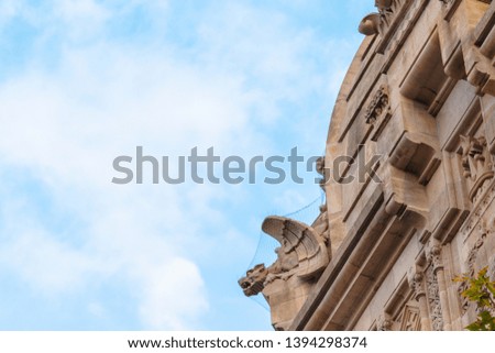 Buildings decorated with stucco and statues against the blue sky and white clouds. On the streets in Catalonia, public places.