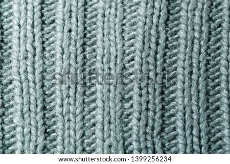 Background texture of dark green rib or cable stitch pattern knitted fabric made of cotton or wool. closeup.