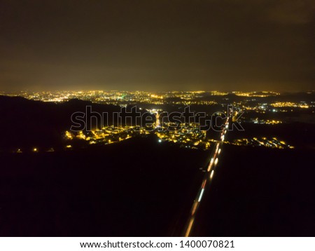 The night aerial view of the dark city with highway
