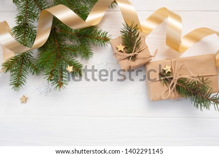 Mockup Christmas white tree, beige bow, gold gift box and cone. Flat lay on a white wooden background, with place for your text. Top view