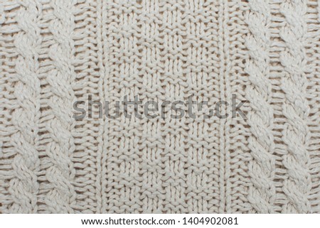 Knitted background, texture, pattern. Closeup of sample with knitting weave.