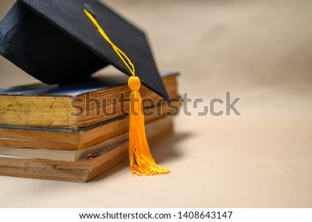 Black Graduation Hat placed on old books