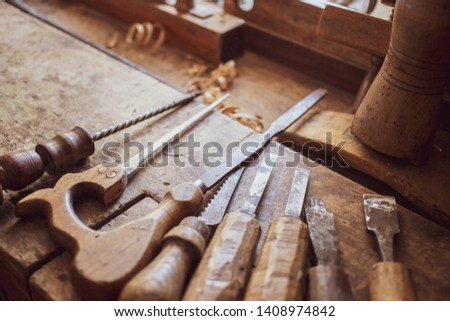 Wood carving tools. Retro stylized old tools on wooden table in a joinery. 
