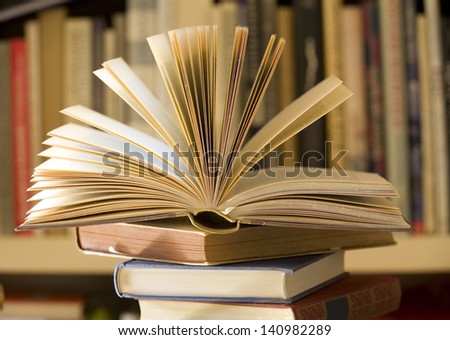 pile of books, one open, selective focus