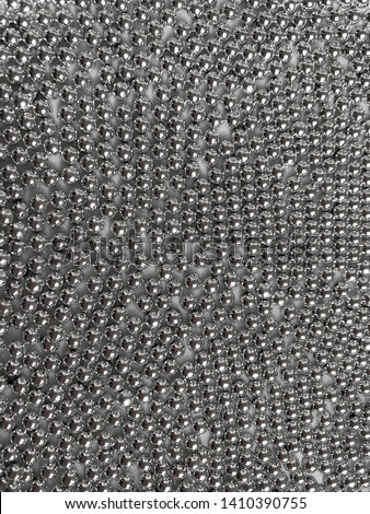 Background - abstraction, shiny metal semi-beads are on a white plate.