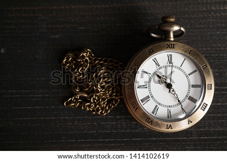 Antique pocket watch Placed on a black wooden background. copy space for text