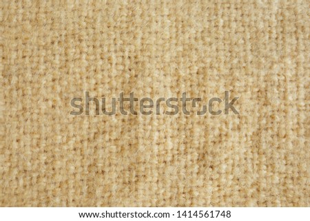 Background picture of a soft fur yellow carpet. wool sheep fleece closeup texture background. Fake color yellow fur fabric. top view