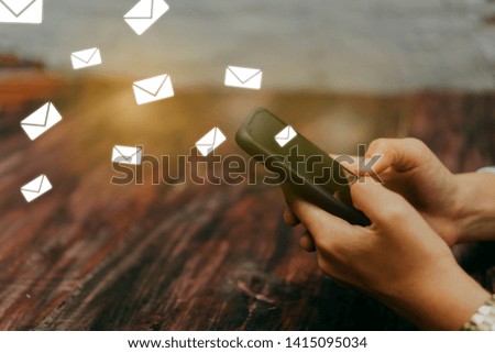 Woman hand using smartphone and it's show email recieve notification icon pop up on screen of mobile phone. Business communication  technology concept.