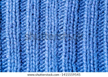 Background texture of sky blue rib or cable stitch pattern knitted fabric made of cotton or wool. closeup.
