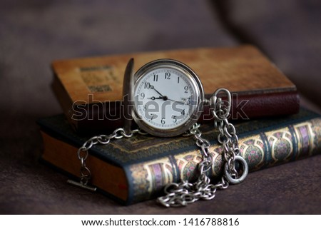 Books and old pocket watch with chain