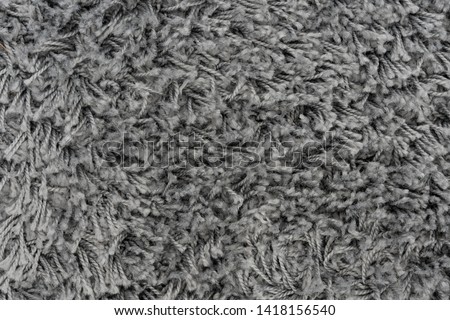 Black natural fleece carpet texture background. Dark wool fabric texture. fragment gray shaggy mat