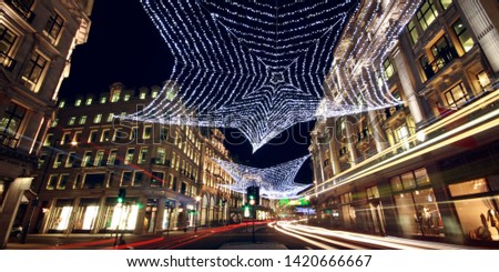 Christmas lights in Regent street with blur of red buses at Christmas at night