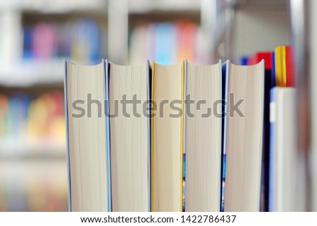 Stack of books on a shelf in a library.
