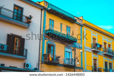 Colorful townhouses or apartments in adjoining buildings with balconies in a close up on the facade