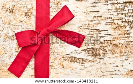 Wooden background made of birch with a big red bow