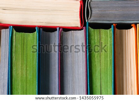 Old books standing in a row on white background	
